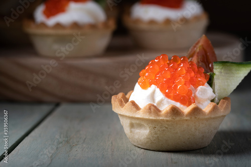 Cheese appetizer with salmon caviar on wooden table