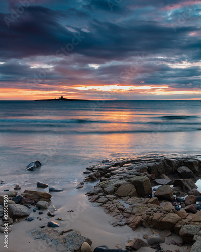 Sunrise at Hauxley Beach on the coast of Northumberland, England UK, with Coquet Island in the distance.