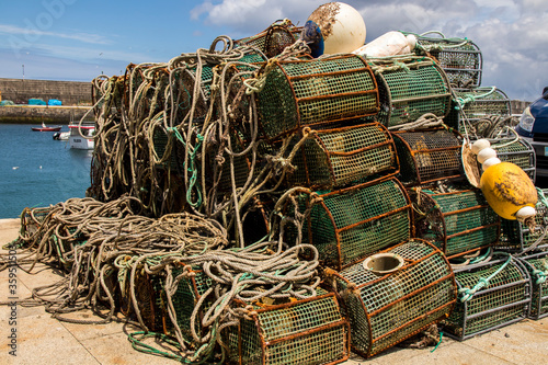 lots of pots and fishing tackle stacked in the port of Malpica de Bergantiños ready to go fishing photo