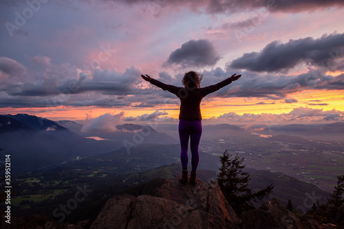 Adventurous Girl on top of a Rocky Mountain overlooking the beautiful Canadian Nature Landscape during a dramatic Sunset. Taken in Chilliwack, East of Vancouver, British Columbia, Canada.