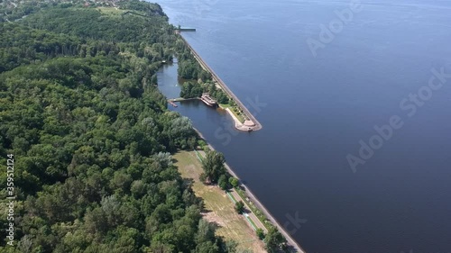 Aerial view. A large exotic wooden ship is located near the shore. Green lagoon. Kiev, Mezhyhirya. Drone
