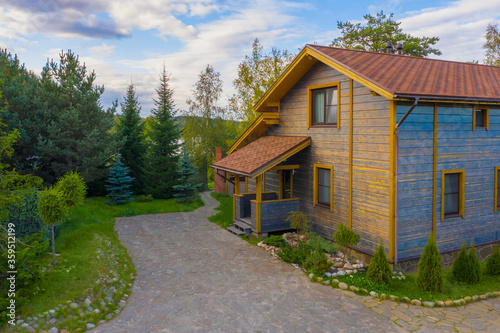 Wooden cottage in a beautiful area. Outdoor recreation. House in a green setting on the banks of the lake. Country rest. Landscape design. Cottage rentals. © Grispb