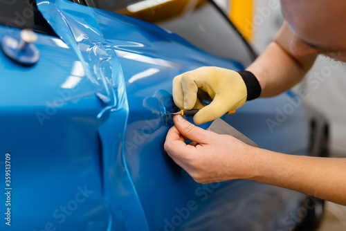 Car wrapper installs protective vinyl foil or film