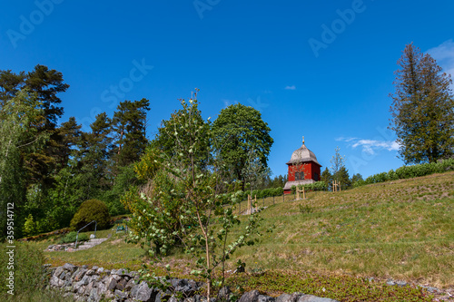 Church spire of a typical Swedish wooden church in a rural setting against a blue sky