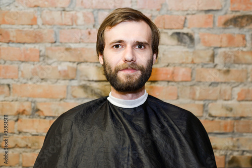 Portrait one freak bearded shaggy guy long hair before haircut in barbershop