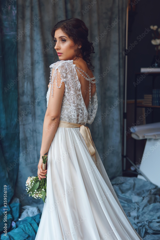 bride in a dress made of crystals with a beautiful little bouquet