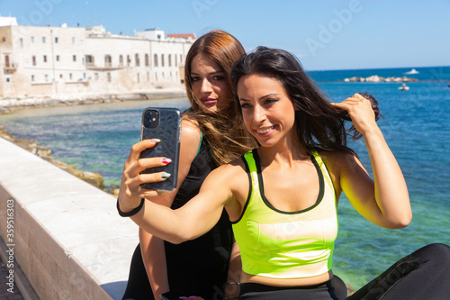 A fun moment to take a selfie with friends during athletic training on the seafront in Molfetta in Puglia photo