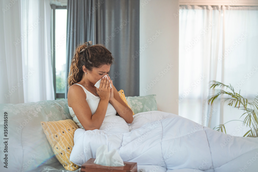 Sickness, seasonal virus problem concept. Woman being sick having flu lying on sofa looking at temperature on thermometer. Sick woman lying in bed with high fever. Cold flu and migraine. Sickness, seasonal virus problem concept. Woman being sick having flu lying on sofa looking at temperature on thermometer. Sick woman lying in bed with high fever. Cold flu and migraine.
