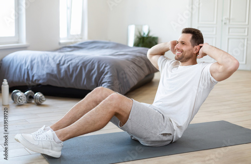 Man Exercising Doing Abs Sitting On Mat Training At Home © Prostock-studio