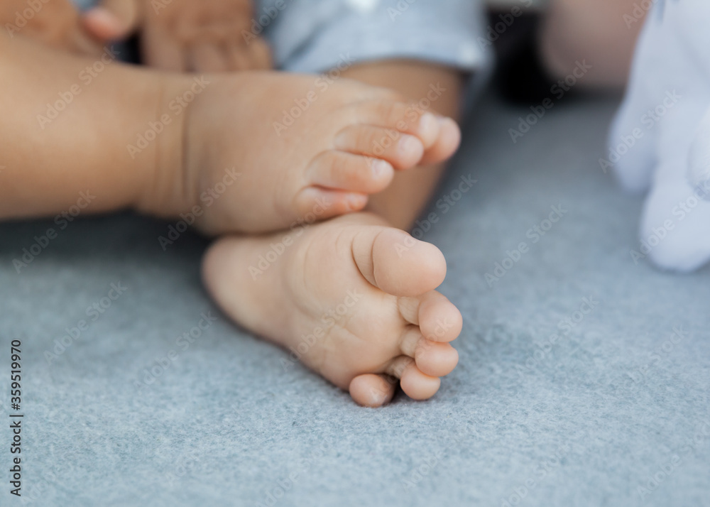 Closeup of adorable baby feet and tiny toes relaxed on soft gray blanket Closeup of adorable baby feet and tiny toes relaxed on soft gray blanket