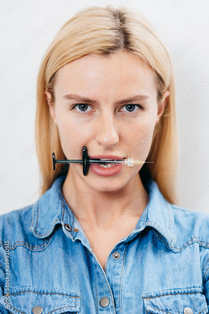Blonde girl with a syringe in her teeth Blonde girl with a syringe in her teeth