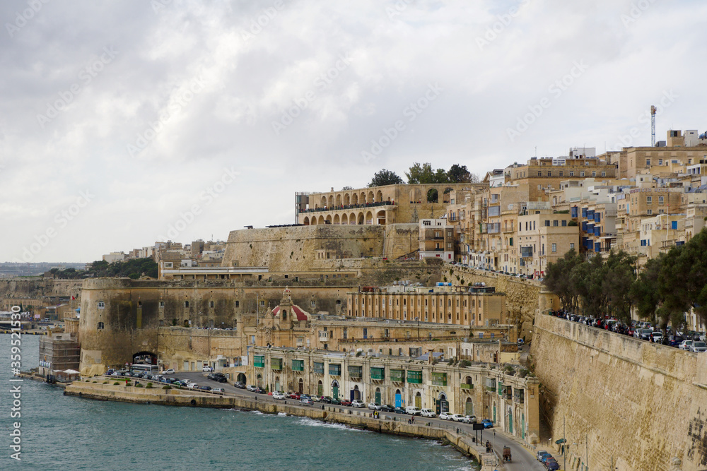 VALLETTA, MALTA - DEC 31st, 2019: Panoramic skyline view of the Grand Harbor of Valletta and Upper Barrakka Gardens at daylight with blue sky during winter