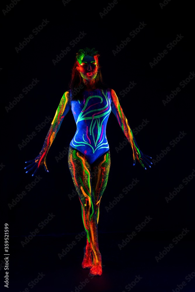 Female model with colorful ultraviolet body in dark Female model with colorful ultraviolet body in dark