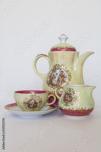 Tea set made of yellow-pink porcelain with gilded painting on the surface.