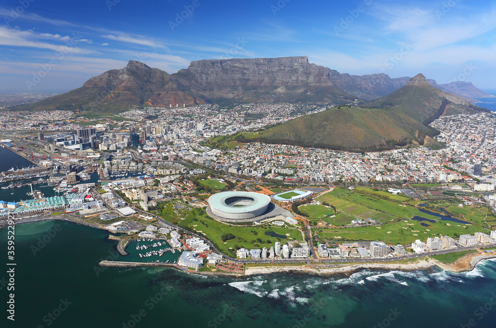 Fototapeta premium Kapsztad, Prowincja Przylądkowa Zachodnia / RPA - 09.04.2017: Zdjęcie lotnicze Sea Point i Cape Town Stadium z Górą Stołową w tle