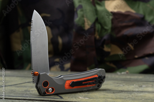 A sharp knife for survival with an orange handle. Clip on the handle. photo