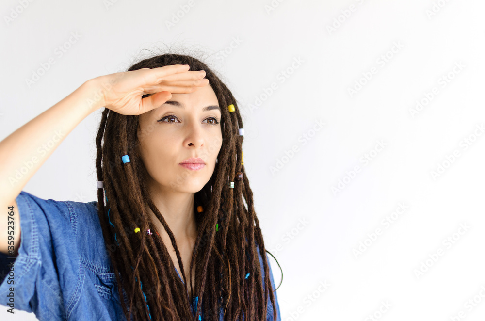 beautiful girl with dreadlocks looks into the distance covering her eyes with her hands beautiful girl with dreadlocks looks into the distance covering her eyes with her hands