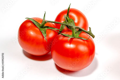 a sprig of red tomatoes is isolated on a white background