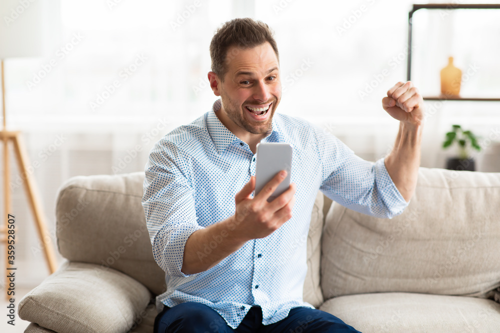 Guy celebrating victory online using cell phone Guy celebrating victory online using cell phone
