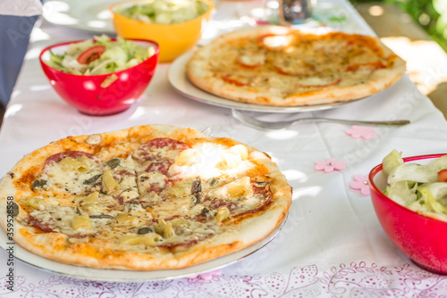 Pieces of pizza on a plate on a table with tablecloth and cutlery, Germany
