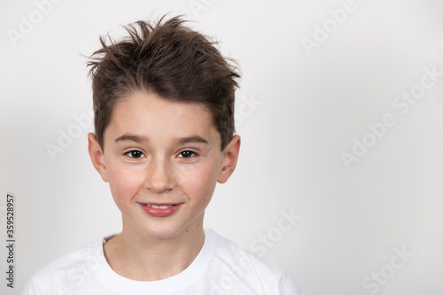 Teenage boy in white shirt. Portrait in studio. Funny faces.