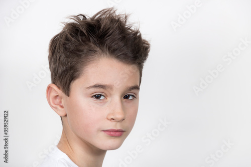 Obraz na płótnie Teenage boy in white shirt. Portrait in studio. Funny faces. w salonie