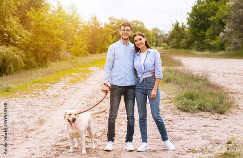 Cute couple and retriever walking in countryside together
