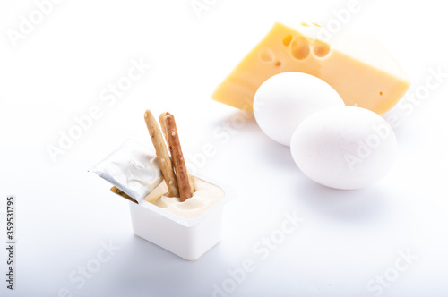 Hard cheese, white eggs and cheese sauce. Try fresh cheese sauce. Breadsticks and mayonnaise. photo