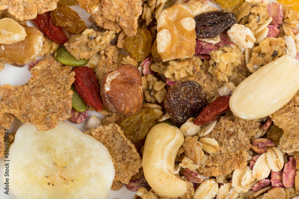 Top View Close up Mixture of granola or muesli on white background, dehydrated fruit mix, healthy food, almond, sun dried cultivated banana, cranberry, cashew nut, pumpkin, melon seed Top View Close up Mixture of granola or muesli on white background, dehydrated fruit mix, healthy food, almond, sun dried cultivated banana, cranberry, cashew nut, pumpkin, melon seed