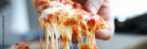 Photos Male arm taking slice of cheesy tasty fresh pizza