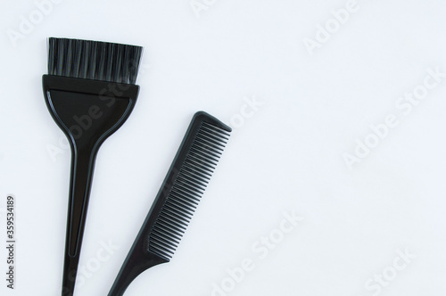 Hairdressing tools. Plastic black comb and brush for coloring hair on white background.