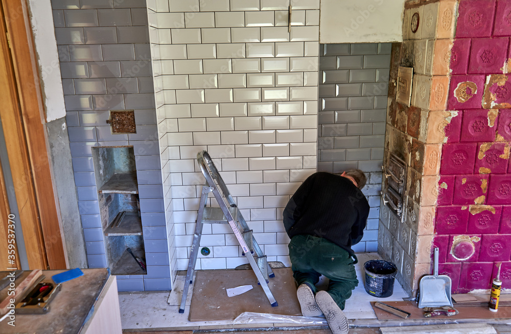 Fototapeta premium Man is filling the gaps between tiles
