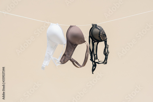 Bild auf Leinwand Female bra is hanging on the rope isolated on a light background.