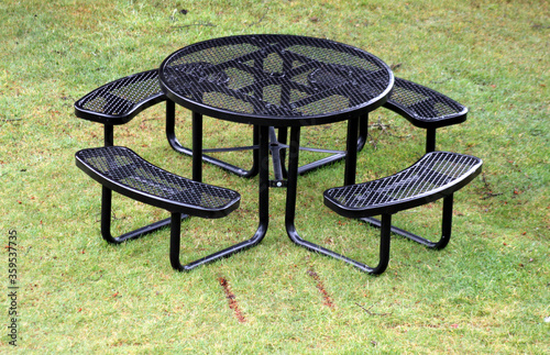 Black metal circular picnic table with four attached benches