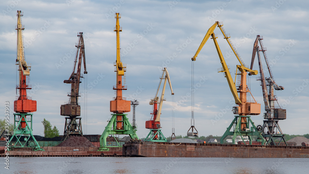 Shipbuilding plant. Crane operation at the shipbuilding, commercial, sea, river, port. Loading, unloading of goods, bulk materials by cranes of the river port (dock).