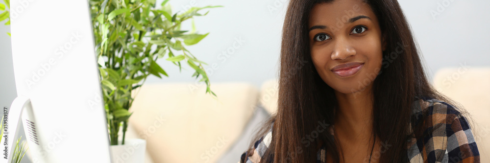 Young beauty black woman hold smartphone in hand against apartments background. Telework home office concept