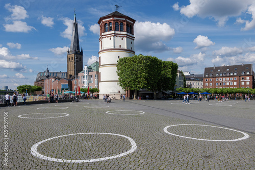 Selected focus at  group of White circles which are drawn on Burgplatz square nearby Rhine River, for concept of Social Distancing and new normal with epidemic of COVID-19 in Düsseldorf, Germany.