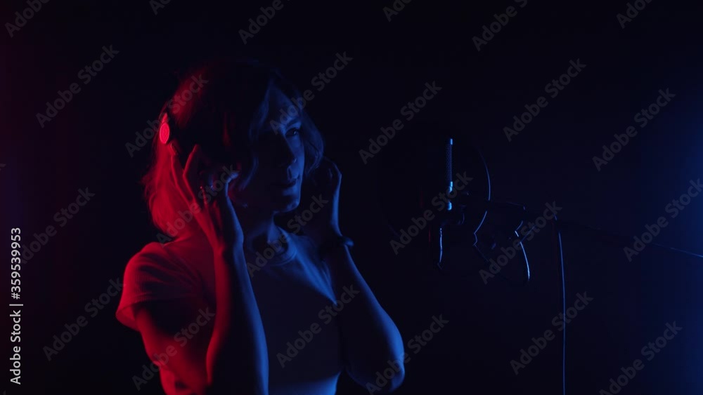 Singing Woman with Microphone. Beauty Glamour professional singer girl close-up. Music studio. Song, pop music concept. 4K UHD Singing Woman with Microphone. Beauty Glamour professional singer girl close-up. Music studio. Song, pop music concept. 4K UHD