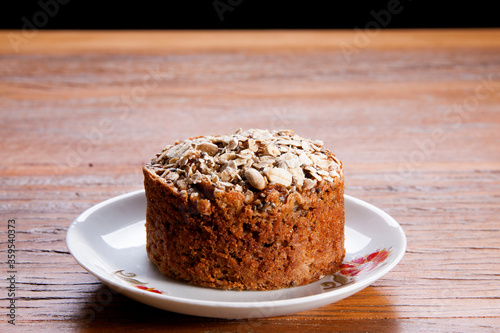 Traditional mini homemade Christmas cake. Holiday dessert with Damascus and dry goji berry on vintage wooden table background. Rustic style.