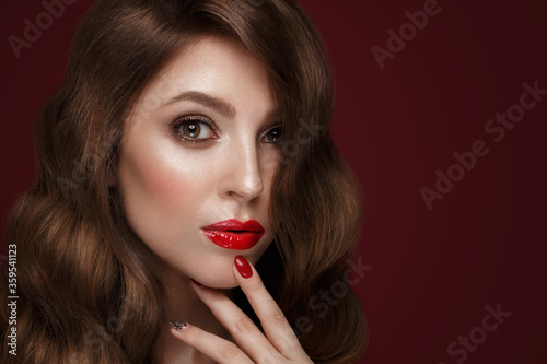 Beautiful girl with a classic make up, curls hair and red nails. Manicure design. Beauty face.