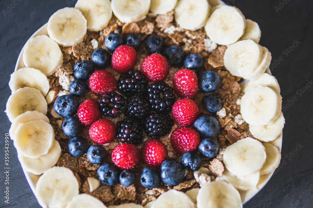 Cereals and fruits superbowl, healthy bowl breakfast with flakes, oat and fruits: strawberries, blueberries, banana, blackberries