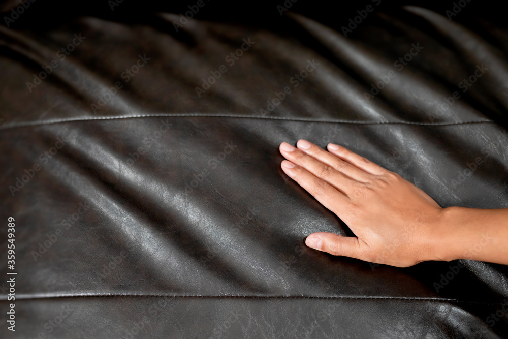 The woman's hand touching the surface of the sofa.