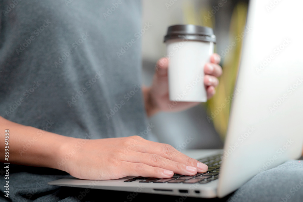 Working woman sitting. She is working with a notebook and is drinking coffee. The concept of women working with technology. Working woman sitting. She is working with a notebook and is drinking coffee. The concept of women working with technology.