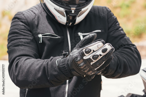 biker puts on his gloves to ride his bike