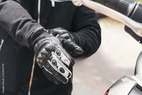 biker puts on his gloves to ride his bike