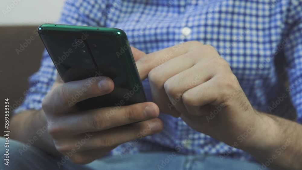 Close up shot - young man surfing net using mobile phone at home office. Close up woman hands using smartphone on couch. Close up shot - young man surfing net using mobile phone at home office. Close up woman hands using smartphone on couch.