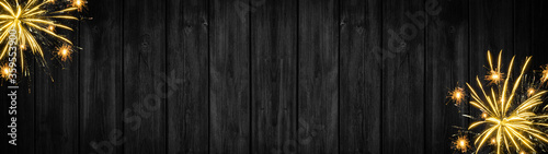 Festive silvester Party celebration background panorama banner long - Golden yellow firework on black rustic wooden wall texture with space for text
