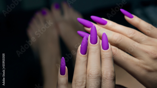 Art Manicure. Modern style violet Nails Polish. Violet long Nails on black background