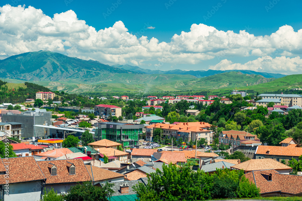 Landscape of the city of Georgia against the backdrop of beautiful picturesque mountains on a sunny summer day