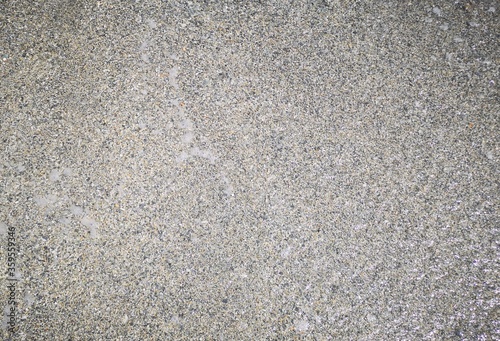 background of sand and small stones of gray color by the Ligurian sea